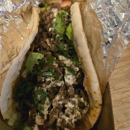 Shredded stringy gyros meat with wilted salad. Shredded stringy gyros meat with wilted salad.