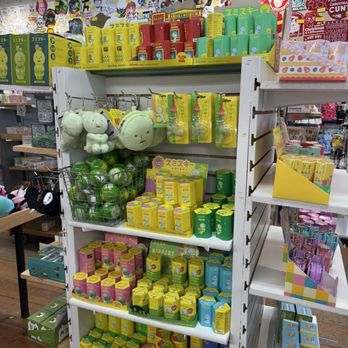 Strange Cargo - A white retail shelf holds Japanese-themed plush toys, keychains, and collectible items, with colorful packaging and a variety of products. - Screen Printing/T-Shirt Printing Near Me - Chicago, Illinois