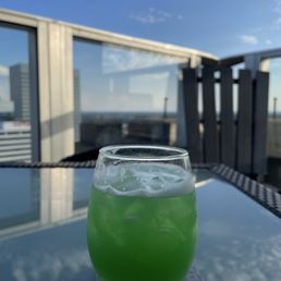 a glass of green drink on a table a glass of green drink on a table