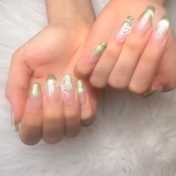 Mila Nails and Spa - My nails - Hands with manicured nails display a gold and white nail art design, resting on a soft, white surface. - Nail Salons Near Me - Gloucester, Massachusetts