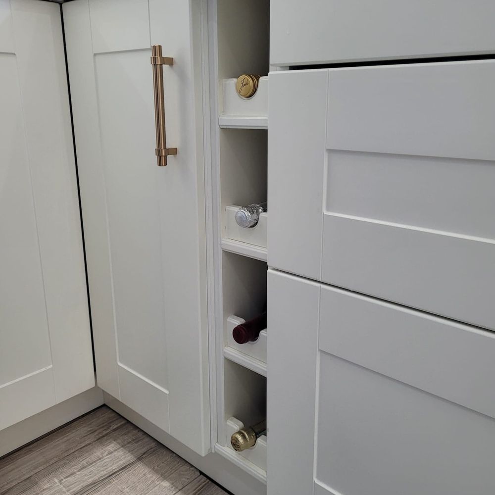 Kaspro Home - a kitchen with white cabinets and marble countertops - General Contractors Near Me