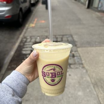 SoBoL - a hand holding a cup of iced coffee - Acai Bowls Near Me - Forest Hills, New York