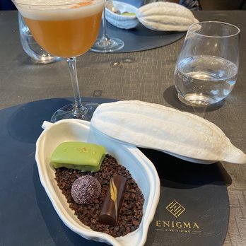Enigma - Pistachio financier, black currant fruit pate and French  dark chocolate with salted caramel inside. The food was amazing. - Modern European Near Me - Toronto, Ontario