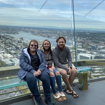 Space Needle - Sitting inside the needle with view of the city behind us. - Landmarks & Historical Buildings Near Me - Seattle, Washington Space Needle - Sitting inside the needle with view of the city behind us. - Landmarks & Historical Buildings Near Me - Seattle, Washington