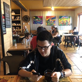 Auberge l'Amarré - a young man sitting at a table in a restaurant - Cafes Near Me - Mont-Louis, Quebec