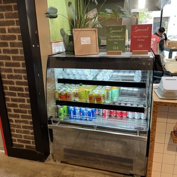Lan Viet - A glass refrigerated display case contains bottled beverages, with signs on top advertising specials for Vietnamese-style dishes and shrimp. - Vietnamese Near Me - Dublin, Ohio