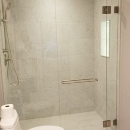 Custom glass door and non movable glass walls in a marble shower.