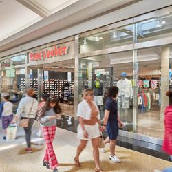 Shoppers walk past the Foot Locker storefront inside Green Acres Mall.