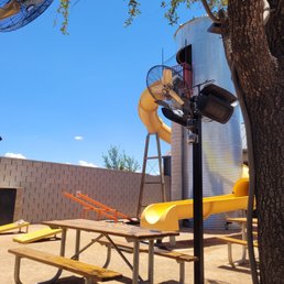 Outside seating, slide, see-saw, cornhole, tv screen.