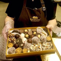 a woman holding a box of chocolates
