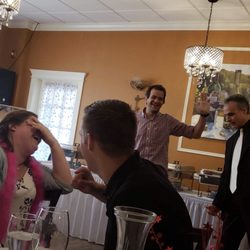 Murder On Cue Mystery Company - Background: Murder on Cue actor (far right, white tie) with my hubby during a scene. Foreground: Some party guests laughing hysterically.
