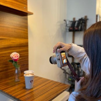 Moore Coffee Shop - a woman taking a picture - Coffee & Tea Near Me - Seattle, Washington