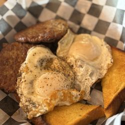 Tucker's On Grand - Over-easy eggs, sausage patties, Texas toast, and crispy roasted potatoes.