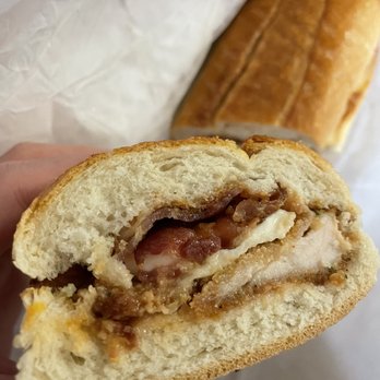 Sundance Deli - a hand holding a half eaten sandwich - Delis Near Me - Pleasantville, New York