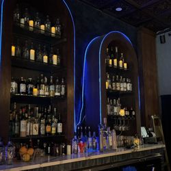 Luna Sea Lounge - Wide bar shot with blue arches: Blue neon arches behind the bar