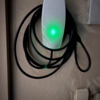 EV Charging Solutions - Tesla Charger installed outside. - Electricians Near Me