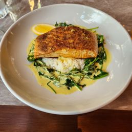 The coconut curry salmon on a bed of rice with sauteed spinach and curry sauce The coconut curry salmon on a bed of rice with sauteed spinach and curry sauce