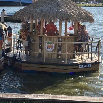 Fox River Brewing - Floating Tiki Boat Docking and passengers debarking - Sports Bars Near Me - Oshkosh, Wisconsin