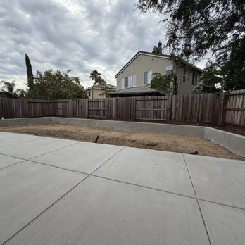 Caligreen Landscaping - Freshly poured cement and retaining wall. - Landscaping Near Me