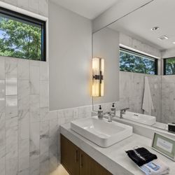 Sunrise Point at Cedar Creek Lake - Sleek and stylish bathroom with marble-tiled walls, a spacious walk-in shower, and a bright vanity.