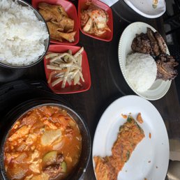 sudubu jjigae, rice, short rib, and half eaten kimchi pajeon with side dishes (banchan)