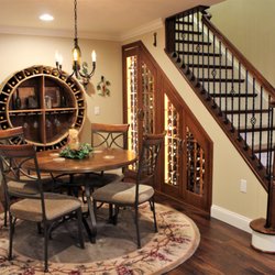 Mione Family Remodeling - Custom made wine storage cabinet. Brand new cherry stair case with wrought iron baluster.