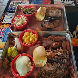 Alma Smokehouse BBQ - Closer plate - 3 meat, 2 sides and tea $18.99  Farther plate - 2 meat, 2 sides and tea $15.99