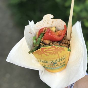 Island Noodles - a hand holding a wrap of food - Food Trucks Near Me Island Noodles - a hand holding a wrap of food - Food Trucks Near Me