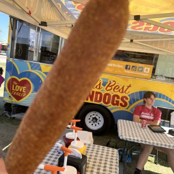 World's Best Corndogs - a person holding a hot dog - Hot Dogs Near Me World's Best Corndogs - a person holding a hot dog - Hot Dogs Near Me