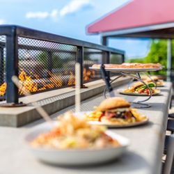 The Brew Brothers - Plates of food in line placed on a bar-style table outdoors.