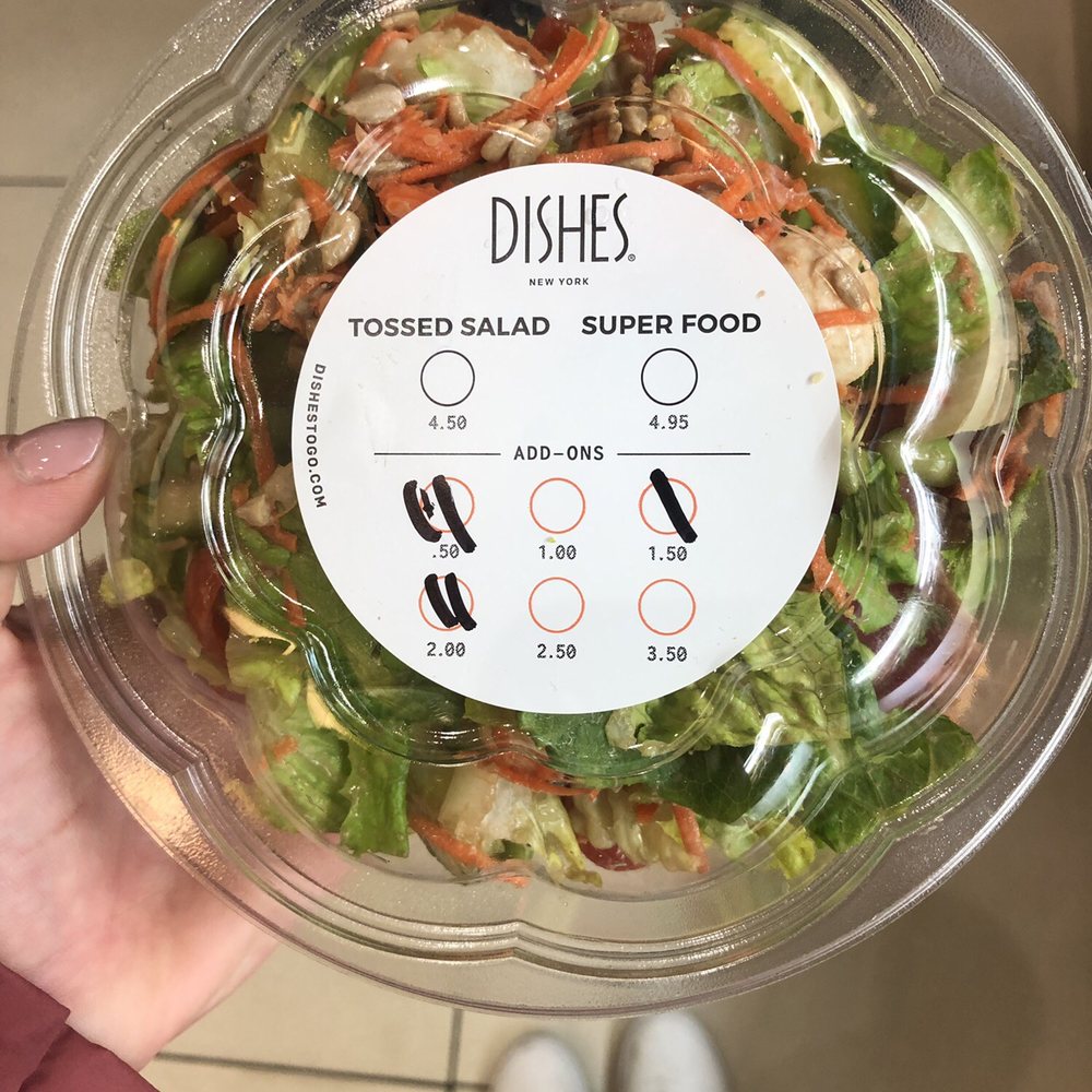 a person holding a bowl of salad