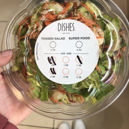 a person holding a bowl of salad