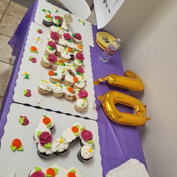 Walmart Supercenter - THERESE'S 70th - A table with cupcakes decorated with colorful flowers and a cake shaped as the number 70, celebrating Therese's 70th birthday, with balloons and party supplies nearby. - Grocery Near Me - Albuquerque, New Mexico