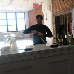 Tapuz Staffing - Tapuz event staff bartender opening bottles in preparation of event