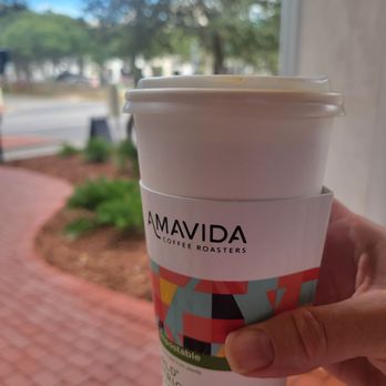 Amavida Coffee Roasters - a hand holding a cup of coffee - Coffee & Tea Near Me - Rosemary Beach, Florida