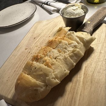 Buonarroti Ristorante - Warm garlic bread with soft whipped garlic butter (with the knife stabbed through the center) - Italian Near Me - Lincoln, California