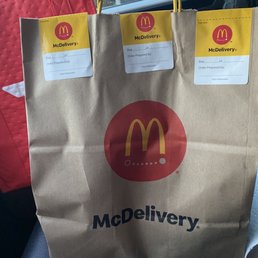 a paper bag with mcdonald's delivery stickers on it