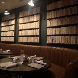 a table with place settings in front of a wall of books