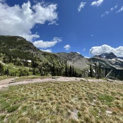 Highline Trail - Pano of the view from the chalet facing the highline trail intersecting with the loop trail and the hill up to grinnell glacier overlook