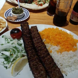 Spicy minced lamb kebab with rice pilaf and grilled tomato