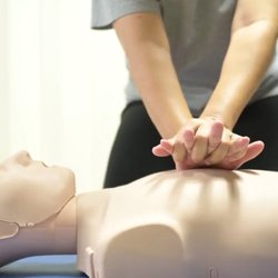 CPR Buddy - Nursing student performing chest compressions on a CPR training mannequin during a hands-on Basic Life Support (BLS) class.