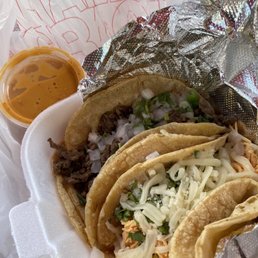three tacos in a styrofoam container three tacos in a styrofoam container