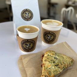 a piece of pizza and two cups of coffee