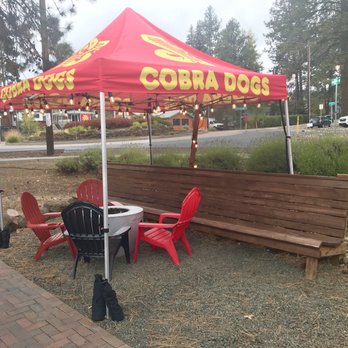 Cobra Dogs - a table and chairs under a canopy - Food Trucks Near Me - Bend, Oregon