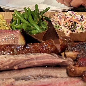 Terry Black's Barbecue - Potato salad, mac n cheese, green beans, coleslaw Banana pudding, brisket with sausage behind and the pork ribs on the right - Barbeque Near Me - Austin, Texas Terry Black's Barbecue - Potato salad, mac n cheese, green beans, coleslaw Banana pudding, brisket with sausage behind and the pork ribs on the right - Barbeque Near Me - Austin, Texas