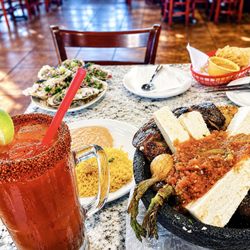 Mariscos El Puerto Escondido - San Bernardino - Massive molcajete plates, fresh tacos, grilled onions, and a spicy michelada packed with flavor at Mariscos El Puerto Escondido