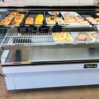 Donutly - a display case filled with various types of donuts - Donuts Near Me - Denton, Texas