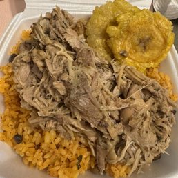 Pernil with yellow rice . Tostones included