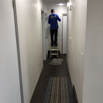 Nailed It Construction - a man standing on a ladder in a hallway - General Contractors Near Me