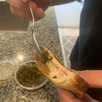 Nora's Empanada Factory - Adding chimichurri - Argentine Near Me - Murrieta, California Nora's Empanada Factory - Adding chimichurri - Argentine Near Me - Murrieta, California